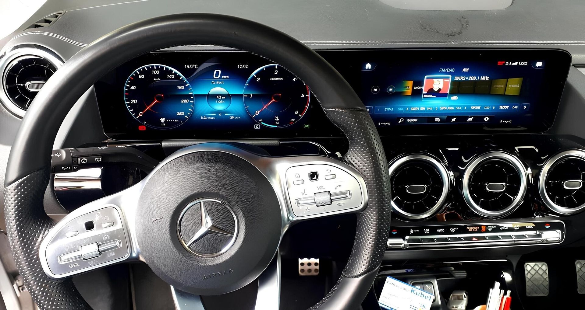 Das Innere eines Mercedes mit einem eleganten Armaturenbrett und einem sportlichen Lenkrad.